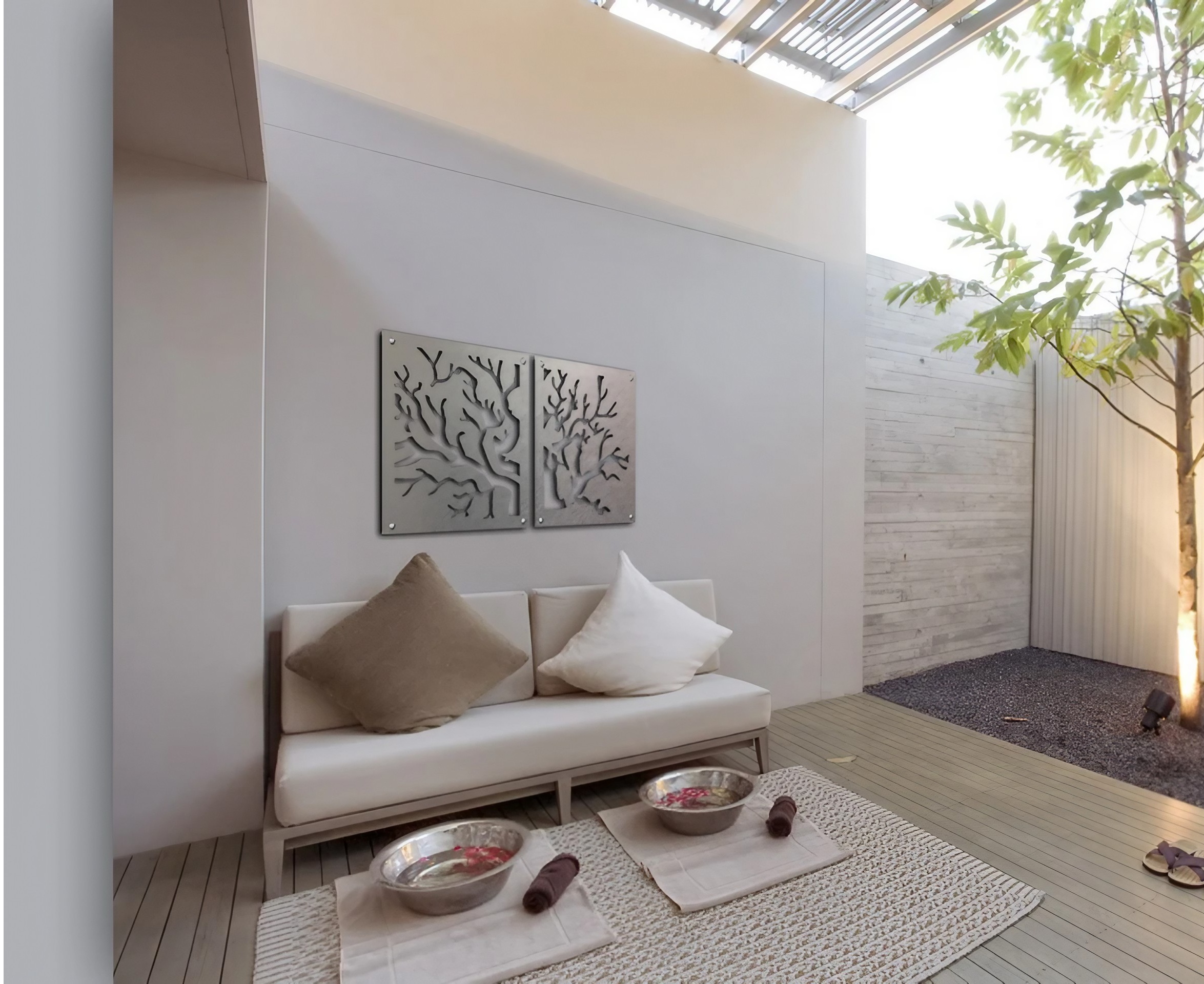 2 Coral Display 1a 2560px 5-23-26 Modern seating area with decorative coral wall art, bowls, and a small tree in a serene space.
