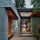 Modern entrance with a large heron artwork, leading to a spacious interior and coastal view.