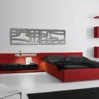 Modern bedroom with red bed, black bedding, minimalist furniture, and abstract wall art.
