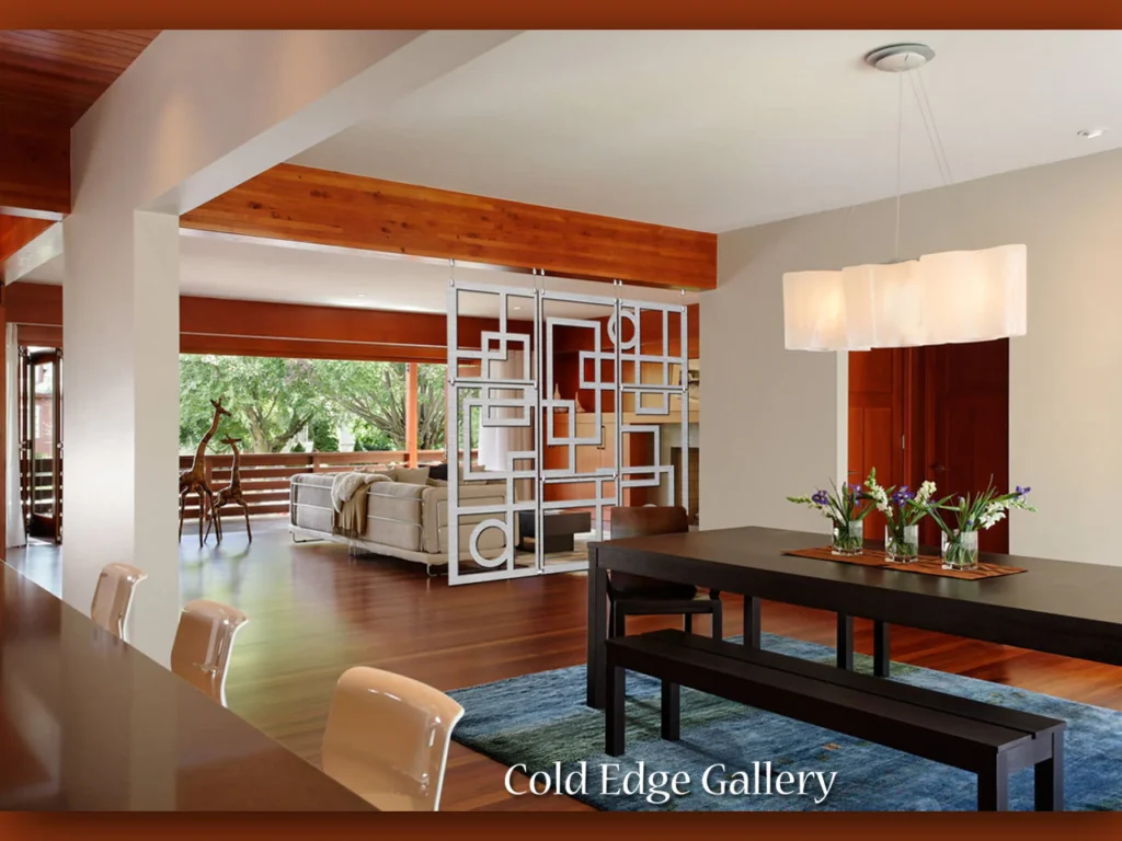 Modern dining area with a dark table, floral centerpiece, and a decorative room divider. Natural light fills the space.