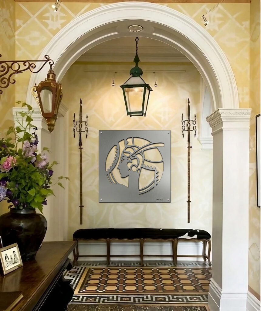 A hallway features a metal art piece of a woman's profile, floral arrangement, and decorative lanterns.