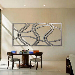 A modern wall art piece with abstract patterns hangs above a round table and chairs in a bright office space.