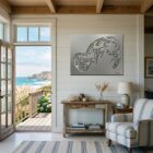 A coastal living room features a decorative manatee wall art, a wooden table, and a view of the ocean.