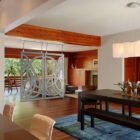 Modern living room features a decorative sliding door, dining table, and vibrant floral arrangements.