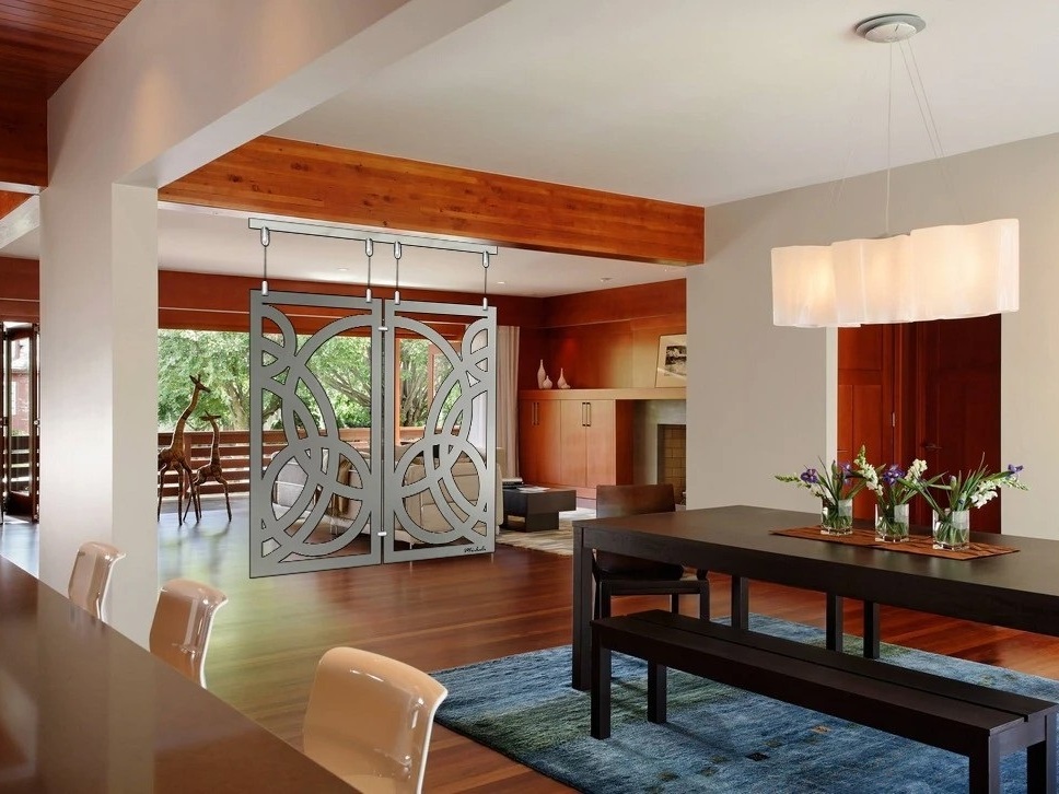 Modern living room features a decorative sliding door, dining table, and vibrant floral arrangements.