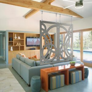Modern living room with a decorative partition, sofa, and large windows overlooking a pool.