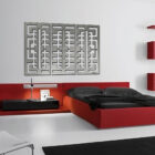 Modern bedroom featuring a red bed, sleek nightstand, and abstract wall art. A unique bookshelf displays stacked books.