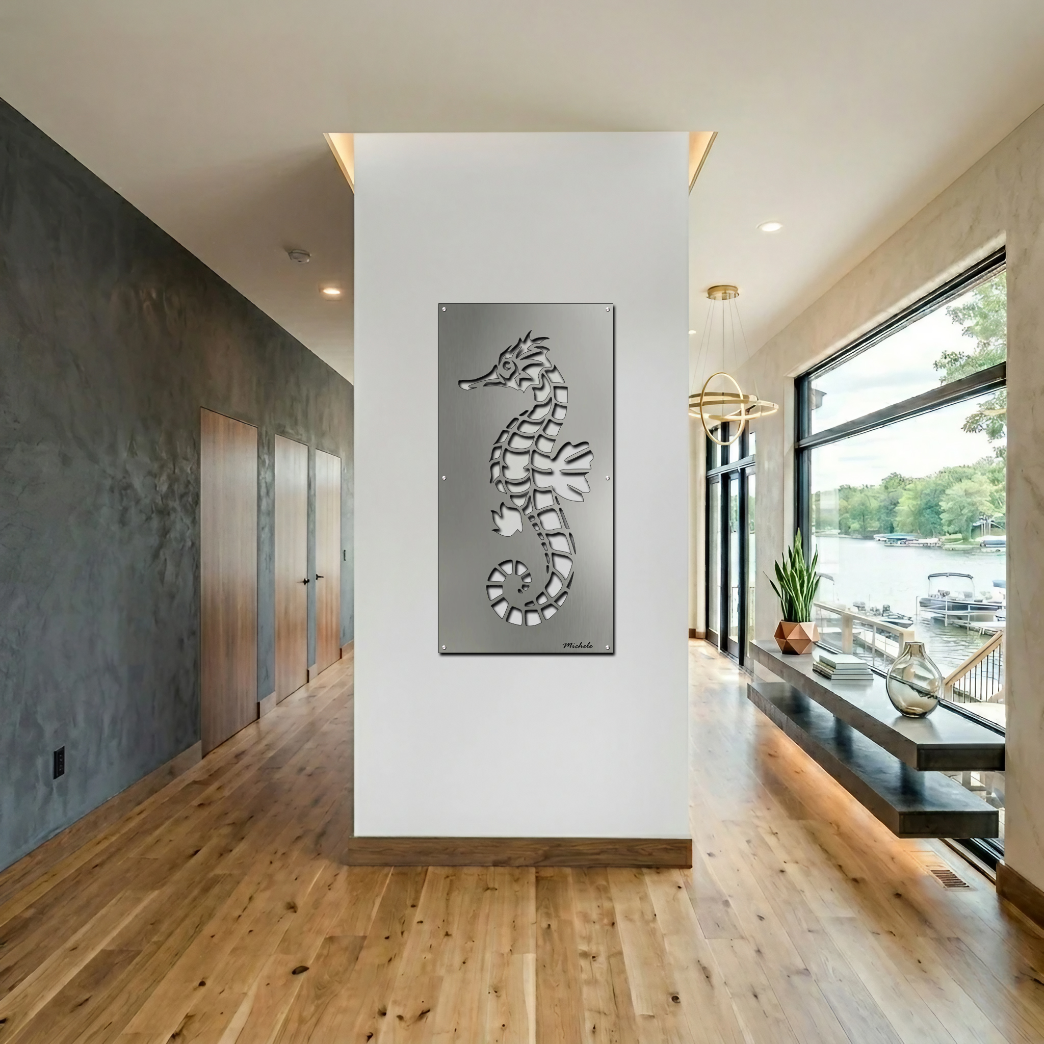 A metal seahorse sculpture hangs on a white wall in a modern coastal interior. Natural light floods the space.
