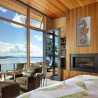 Coastal bedroom with large windows, seahorse artwork, and a view of the water and bridge.