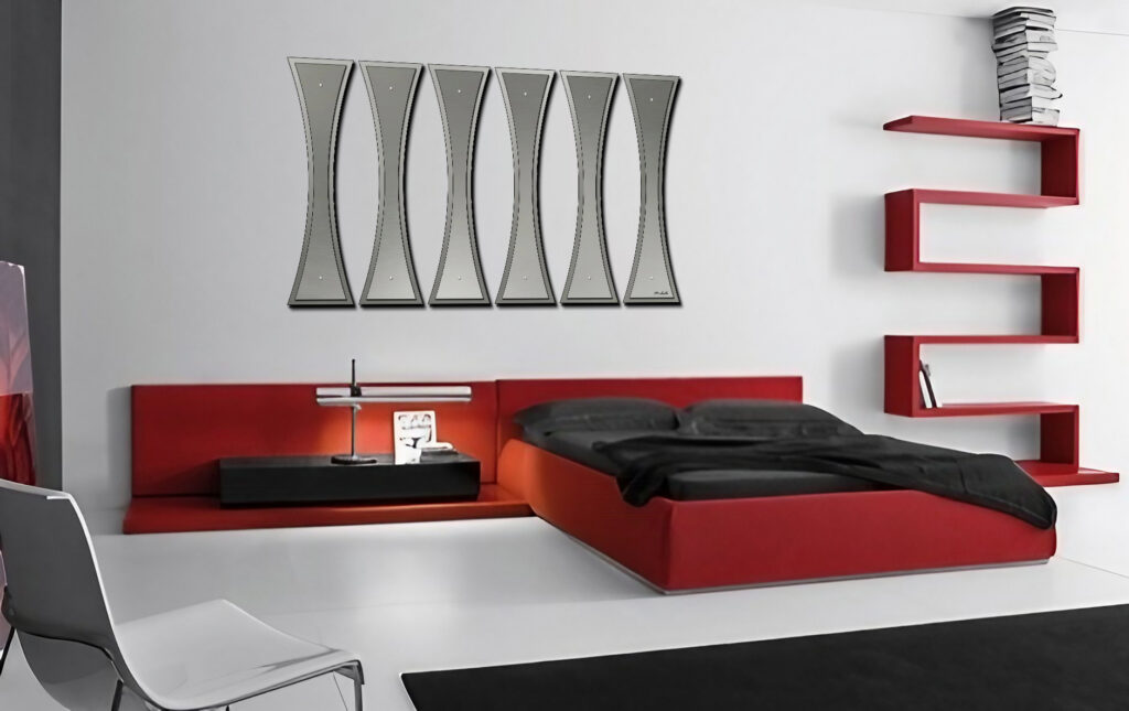 Modern bedroom featuring a red bed, black bedding, a sleek lamp, and a unique wall art piece.
