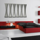 Modern bedroom featuring a red bed, black bedding, a sleek lamp, and a unique wall art piece.