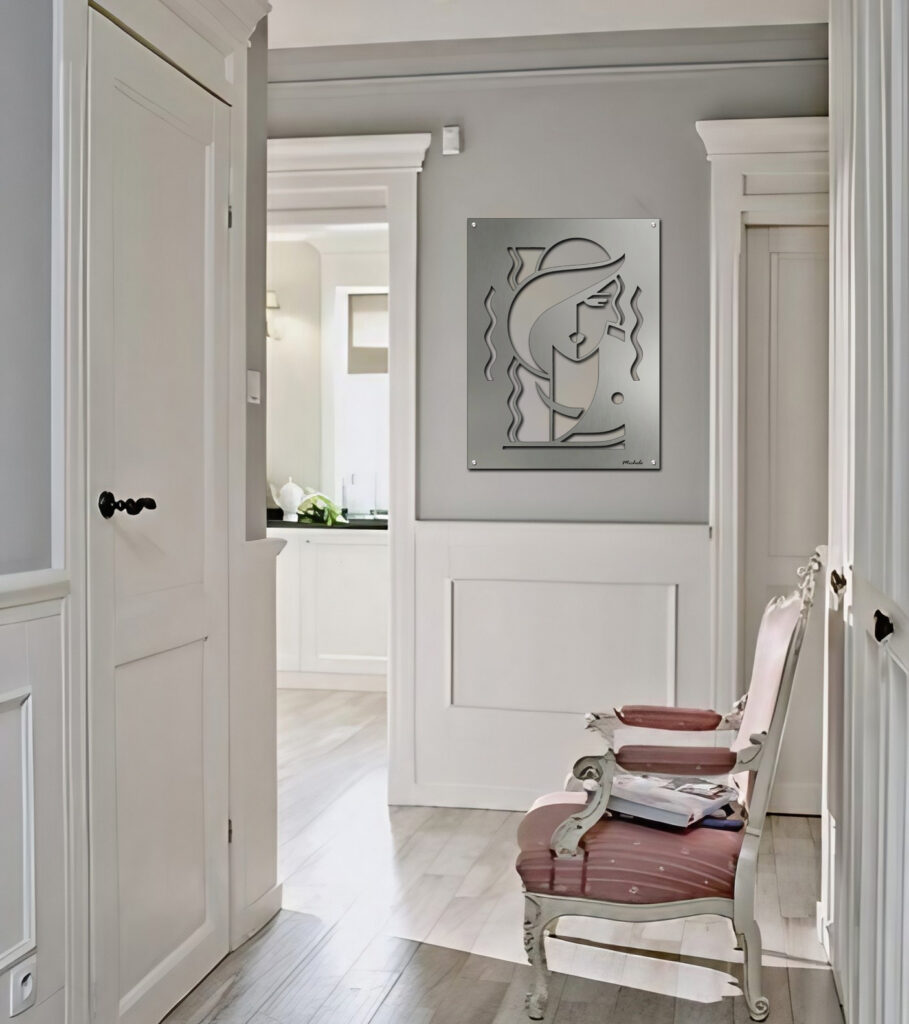 A hallway features a decorative wall art piece and a pink upholstered chair with magazines.