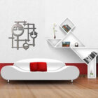 Modern living room features a white sofa with red cushions, geometric wall art, and unique shelving with books and a vase.
