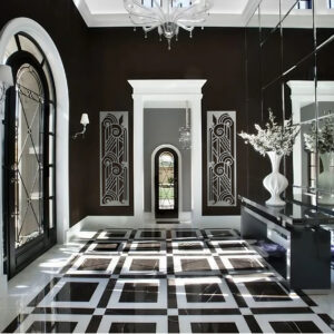 Elegant foyer with black and white checkered floor, decorative wall panels, and a large vase of flowers.