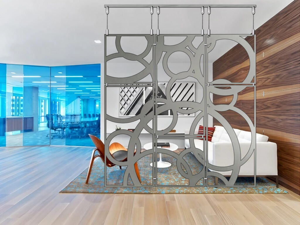 A modern living room features a decorative partition, white sofa, and wooden accents. Blue glass walls in the background.