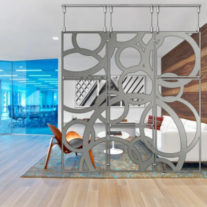 A modern living room features a decorative partition, white sofa, and wooden accents. Blue glass walls in the background.