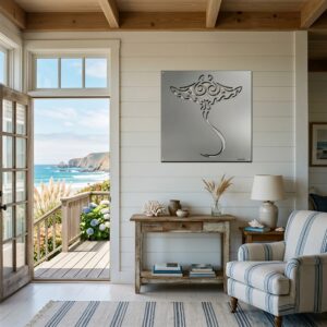 A coastal living room features a manta ray metal art piece on the wall, with ocean views through the doorway.
