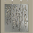 Metal artwork featuring weeping willow branches, displayed in a gallery setting.
