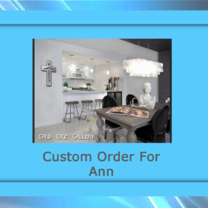 A modern kitchen and dining area featuring a silver cross on the wall, bar stools, a chandelier, a decorative bust, and a wooden dining table with custom artwork. Text: "Custom Order For Ann.