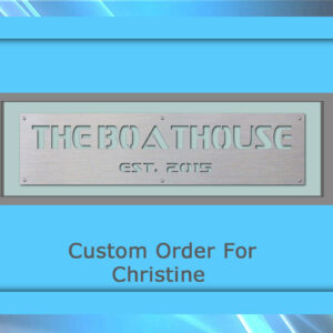 A metal plaque with the text "THE BOATHOUSE EST. 2015" inside a grey and blue frame. Below, in blue, are the words "Custom Order For Christine". This custom artwork perfectly blends functionality and elegance.