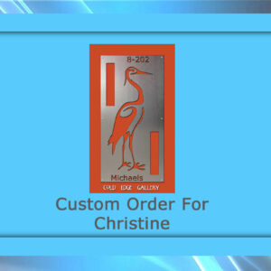 A custom metal sign featuring a red crane design with the text "8-202," "Michaels," and "Gold Eagle Gallery." The artwork is bordered in blue with the words "Custom Order For Christine.