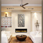 Modern living room with white sofas, a round wooden coffee table, and built-in shelves flanking a wall-mounted fireplace. Artwork and a sculptural figure decor are on display, with "Cold Edge Gallery" text overlay.