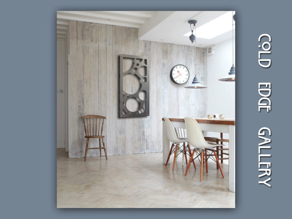 A minimalist gallery space features a wooden wall, a clock, and modern chairs around a table.