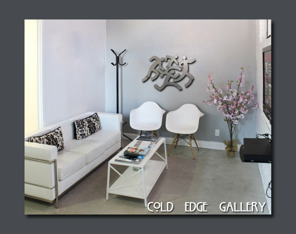 Modern gallery interior with white furniture, a decorative tree, and abstract wall art.
