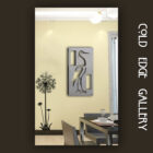 A modern dining room with a beige wall featuring a metal artwork of a bird and a decal of a plant. Text on the right reads "COLD EDGE GALLERY".