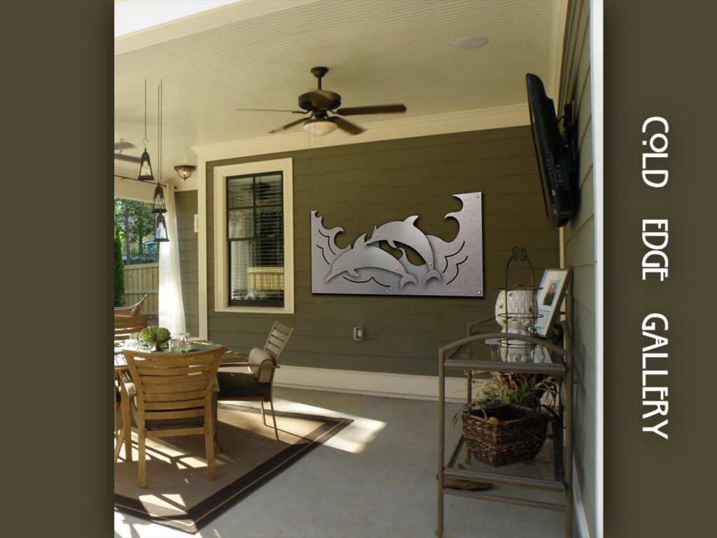 Outdoor patio with a dining table, decorative metal artwork, and a ceiling fan.