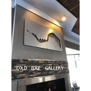 Metal wall art depicting a mountain range above a stone fireplace, with "COLD EDGE GALLERY" displayed below.