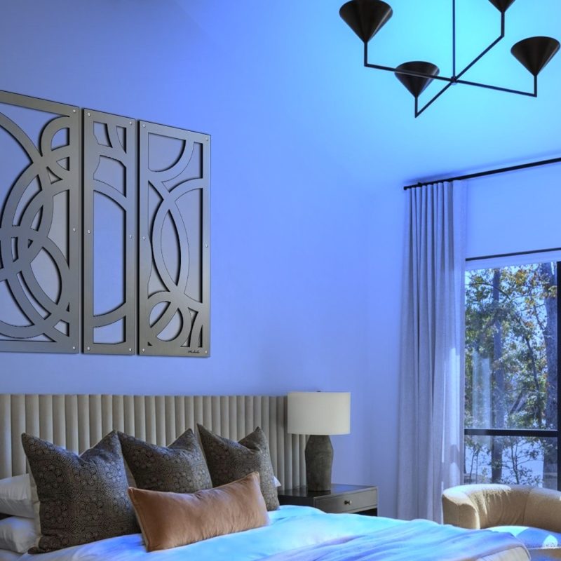 Modern bedroom featuring a patterned wall art, plush pillows, and large windows with a view of trees.